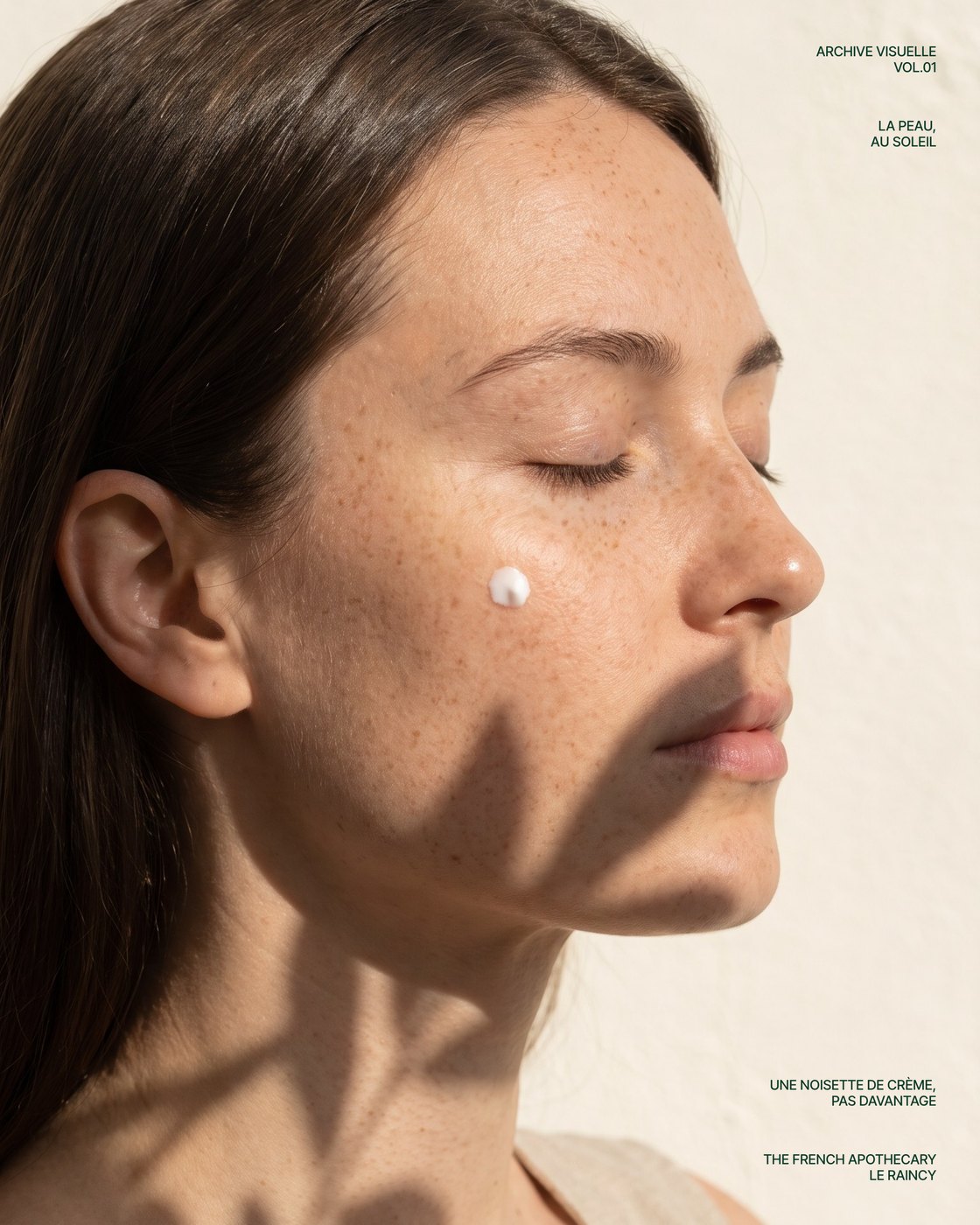 Archive visuelle : une femme, les yeux fermés au soleil, une noisette de crème sur la joue